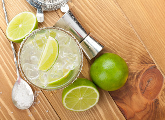 Classic margarita cocktail with salty rim on wooden table