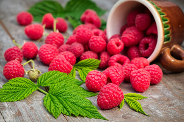 Red ripe raspberries on a wooden background