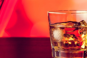 whiskey glass on bar table with ice with space for text