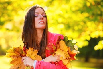 Naklejka na ściany i meble Fall season. Portrait girl woman holding autumnal leaves in park