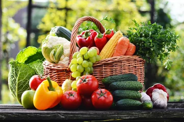 Photo sur Plexiglas Légumes Wicker basket with assorted raw organic vegetables in the garden