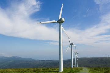 Onshore wind farm - large wind turbines in a row - obrazy, fototapety, plakaty