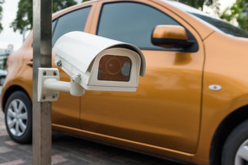 Fototapeta premium CCTV Camera or surveillance Operating in with car drive by in ba
