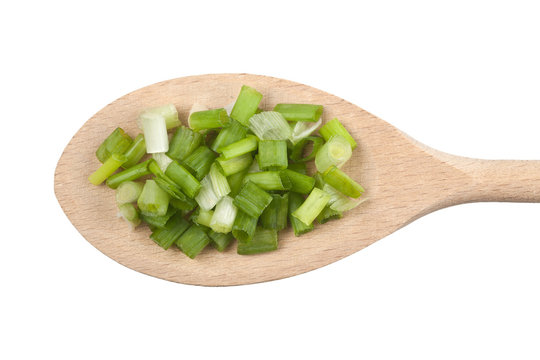 Chopped spring onion on wooden spoon isolated on white