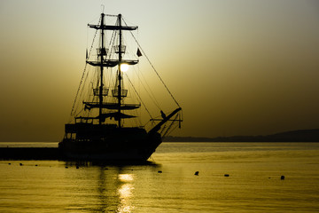Obraz premium Beautiful sunset over the sea. Sailboat in the bay.