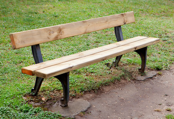 Fototapeta na wymiar Wooden bench in the park on grass