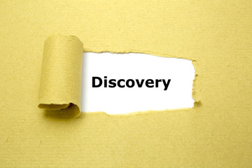 Discovery text appearing behind torn brown paper.