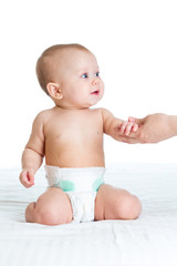mother supporting baby by hands