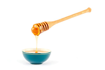 Honey flowing from dipper in a bowl