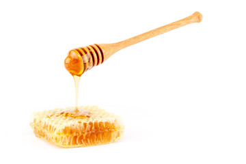 Honey flowing from dipper on honeycomb