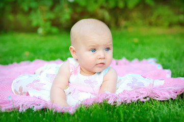 baby smiling and looking up to camera outdoors in sunlight