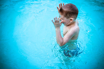 Fototapeta na wymiar Child Enjoying Swimming in a Pool