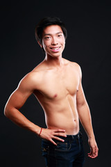 Fototapeta premium Portrait of a cheerful asian man standing on black background