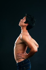 Portrait of asian man stretching on black background