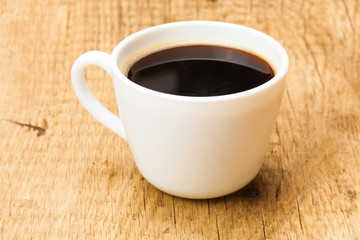 Black coffee in white ceramic cup on wooden table - studio shoot