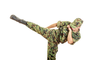 soldier in a green camouflage uniform kicking