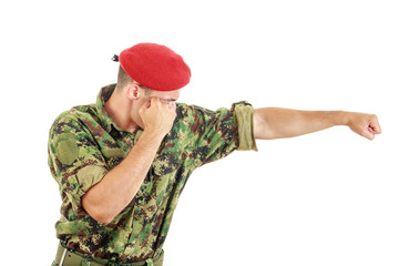 Fototapeta premium Soldier in military uniform and cap hitting with fist