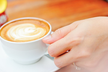 Woman hand with a white cup coffee