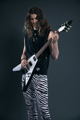 Male hard rock electric guitar musician with long hair. Studio s