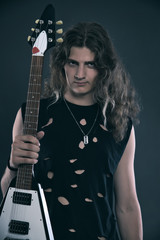 Fototapeta na wymiar Male hard rock electric guitar musician with long hair. Studio s