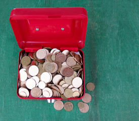 Rectangular red open suitcase with Ukrainian coins
