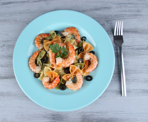 Fresh prawns with coloured macaroni, olives and parsley in a
