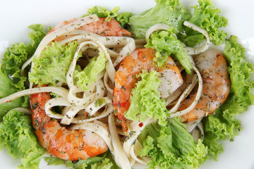 Fresh prawns with spaghetti, olives and lettuce closeup