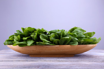 Tuft of fresh sorrel in wooden plate on wooden background