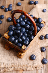 Delicious blueberries in wooden basket on table close-up