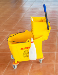 Mop bucket and wringer with caution sign on the floor © mrcmos