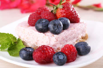Cake with fruits and berries on plate on wooden background
