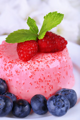 Round shaped cake with berries on plate on wooden background