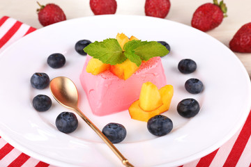 Heart shaped cake with fruits and berries on plate on napkin