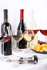 Bottles and glasses of wine, cheese and ripe grapes