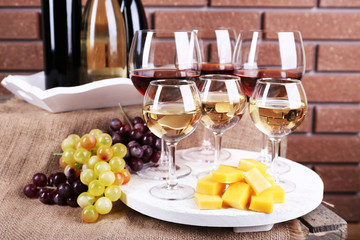 Bottles and glasses of wine, cheese and ripe grapes