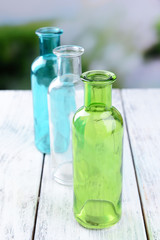 Empty glass bottles on table on bright background
