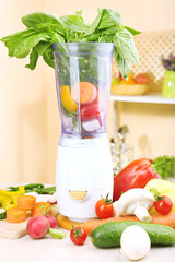 Blender with fresh vegetables on kitchen table