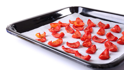 Sun dried tomatoes on drying tray, isolated on white