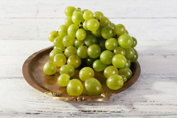 Green grape on tray on wooden background