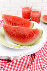 Juicy watermelon on table on brick wall background