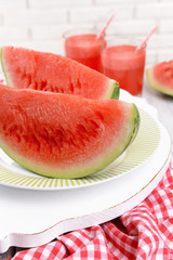 Juicy watermelon on table on brick wall background