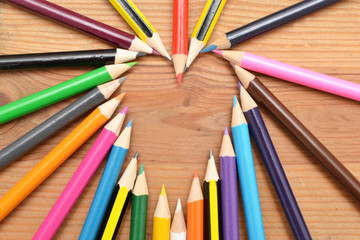 Fototapeta premium Colored pencils on wood with heart form