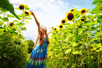 Bambina felice nel campo di girasoli