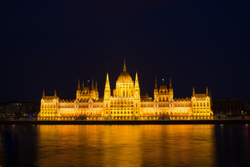 Budapest parliament building at night illuminated over the river