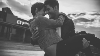 guy holding girl in his arms as they have a romantic moment