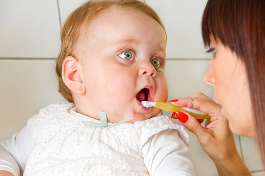Mutter putzt Zähne ihres Babys