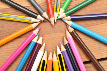 Naklejka premium Colored pencils on wood with heart form