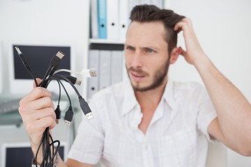 Confused computer engineer looking at wires