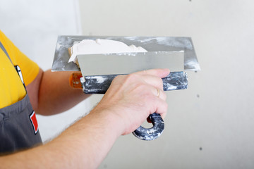 repairman works with plasterboard, prepairing plaster for plaste