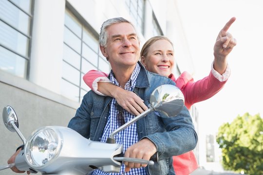 Happy Senior Couple Riding A Moped